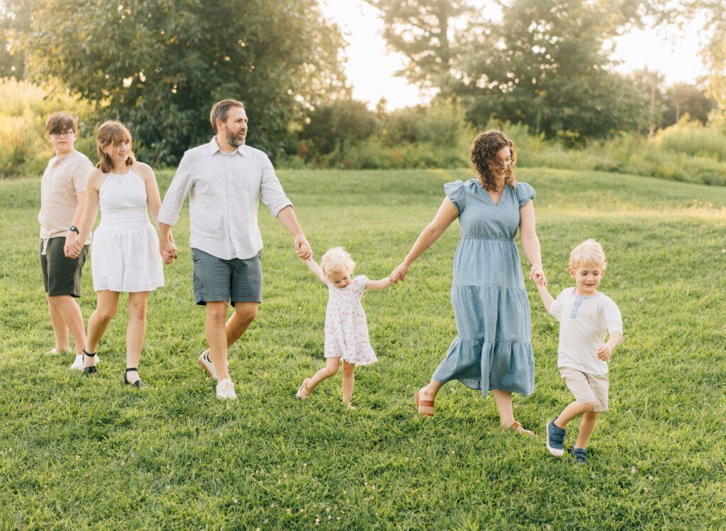 A family playing follow the leader with a little boy leading.