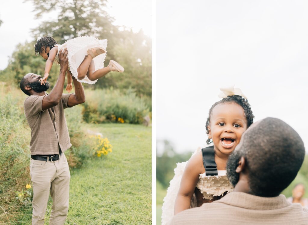 A mom and dad face their daughter and lift her up into the air. She has a big smile on her face.