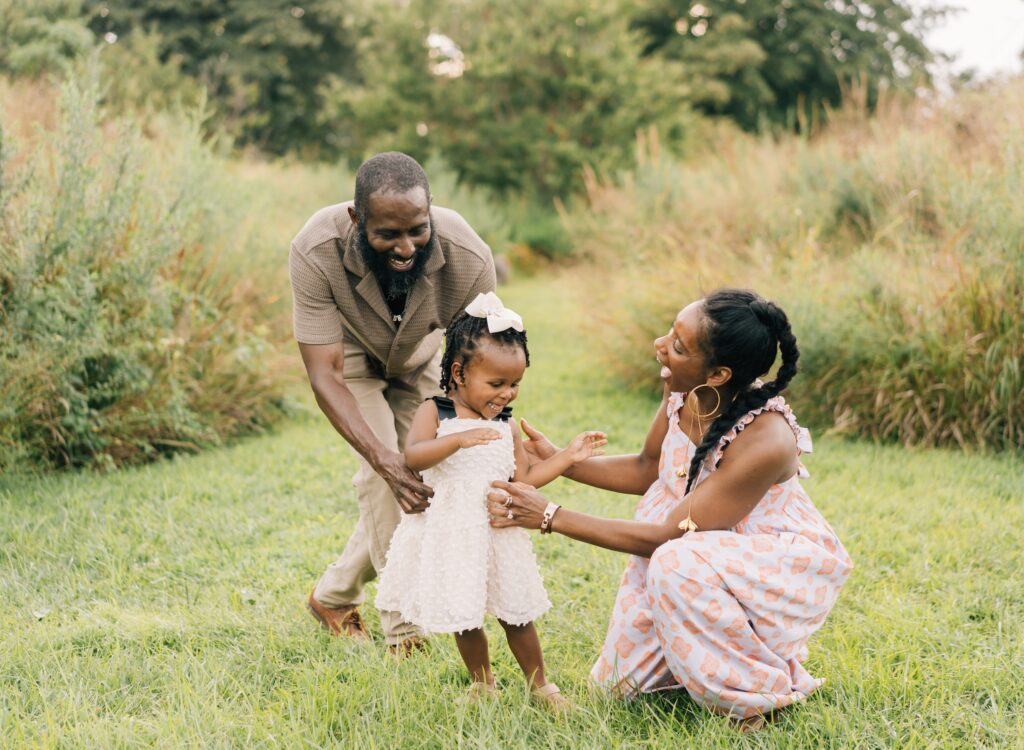 Parents tickles their daughter.