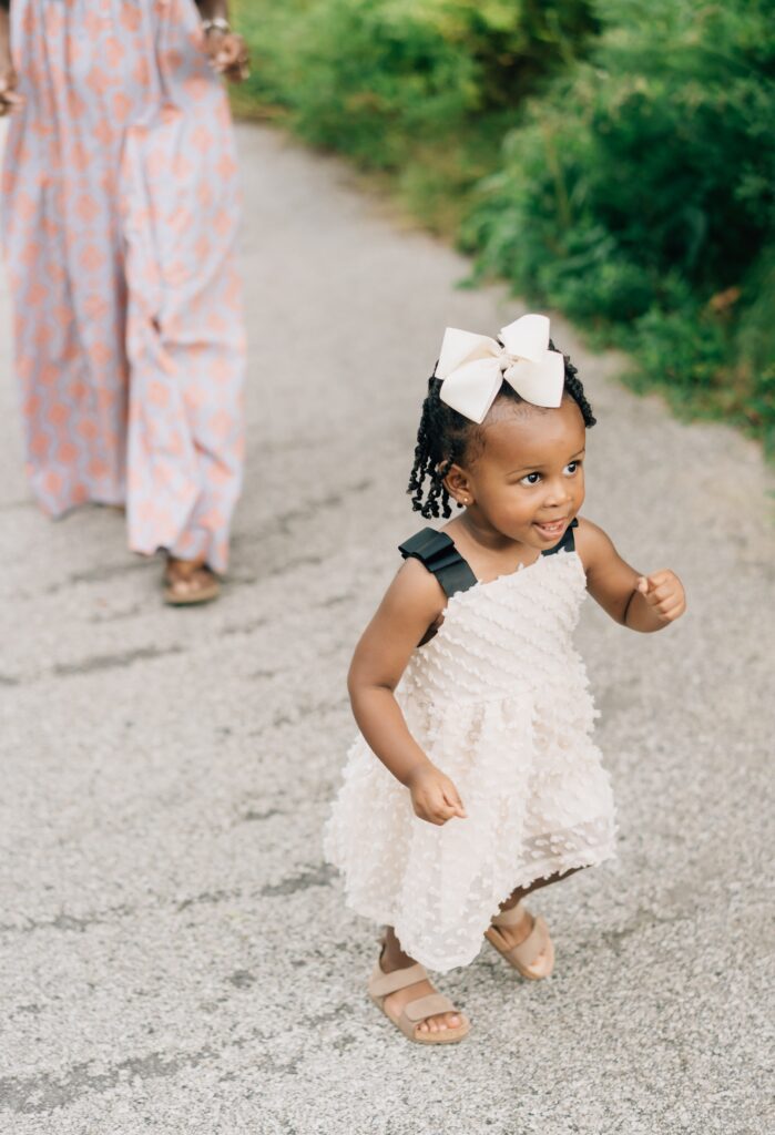 A little girl is running down a path.