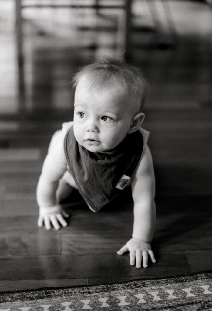 A black and white picture of a baby looking off into the distance while wearing a bandana for st. louis in home family photos.