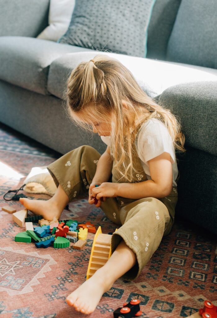 A toddler girl playing with her toys