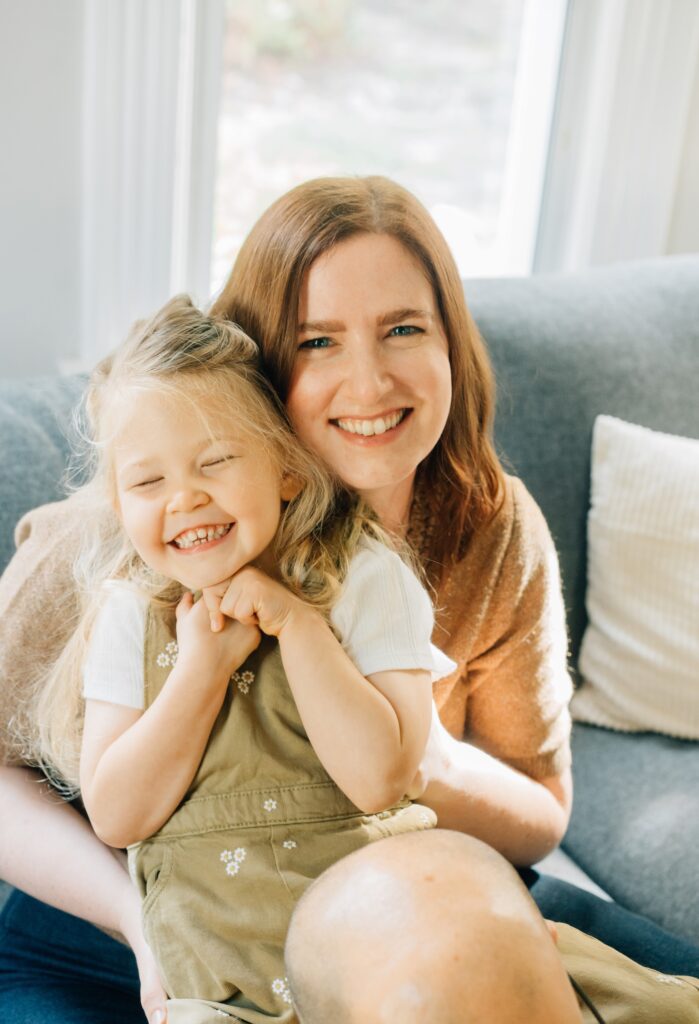 A mom and daughter smiling at the camera.